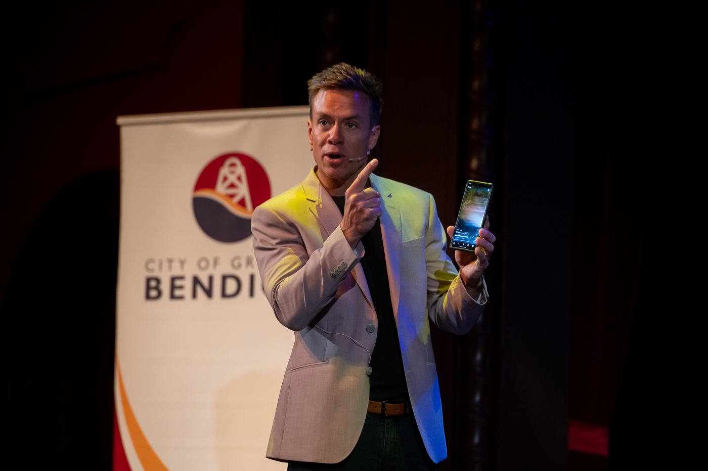 Joel presenting with a phone in hand